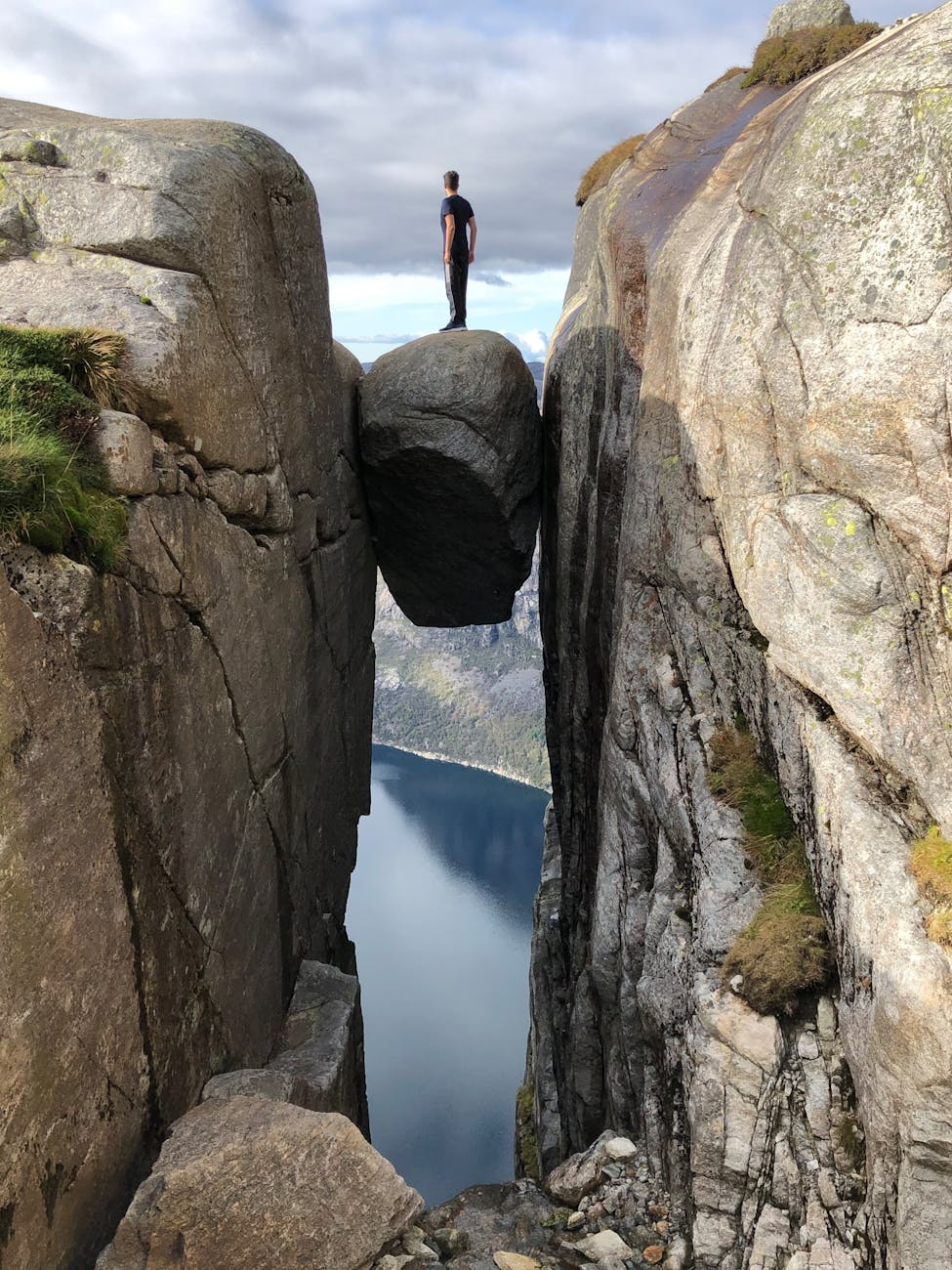 person standing on a rock stocked between rocks