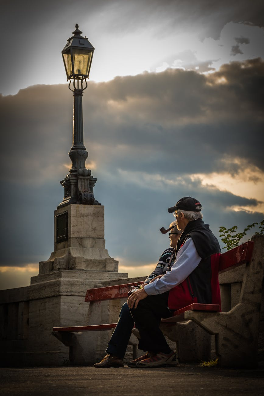 man in pipe beside woman wearing black frame eyeglasses during day time
