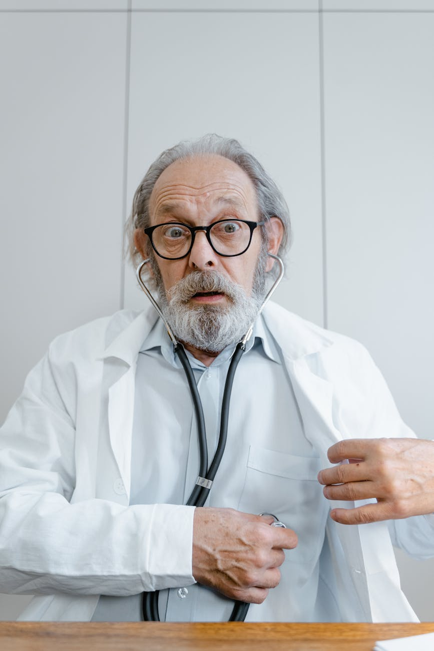 doctor wearing eyeglasses while listening to his heartbeat using his stethoscope