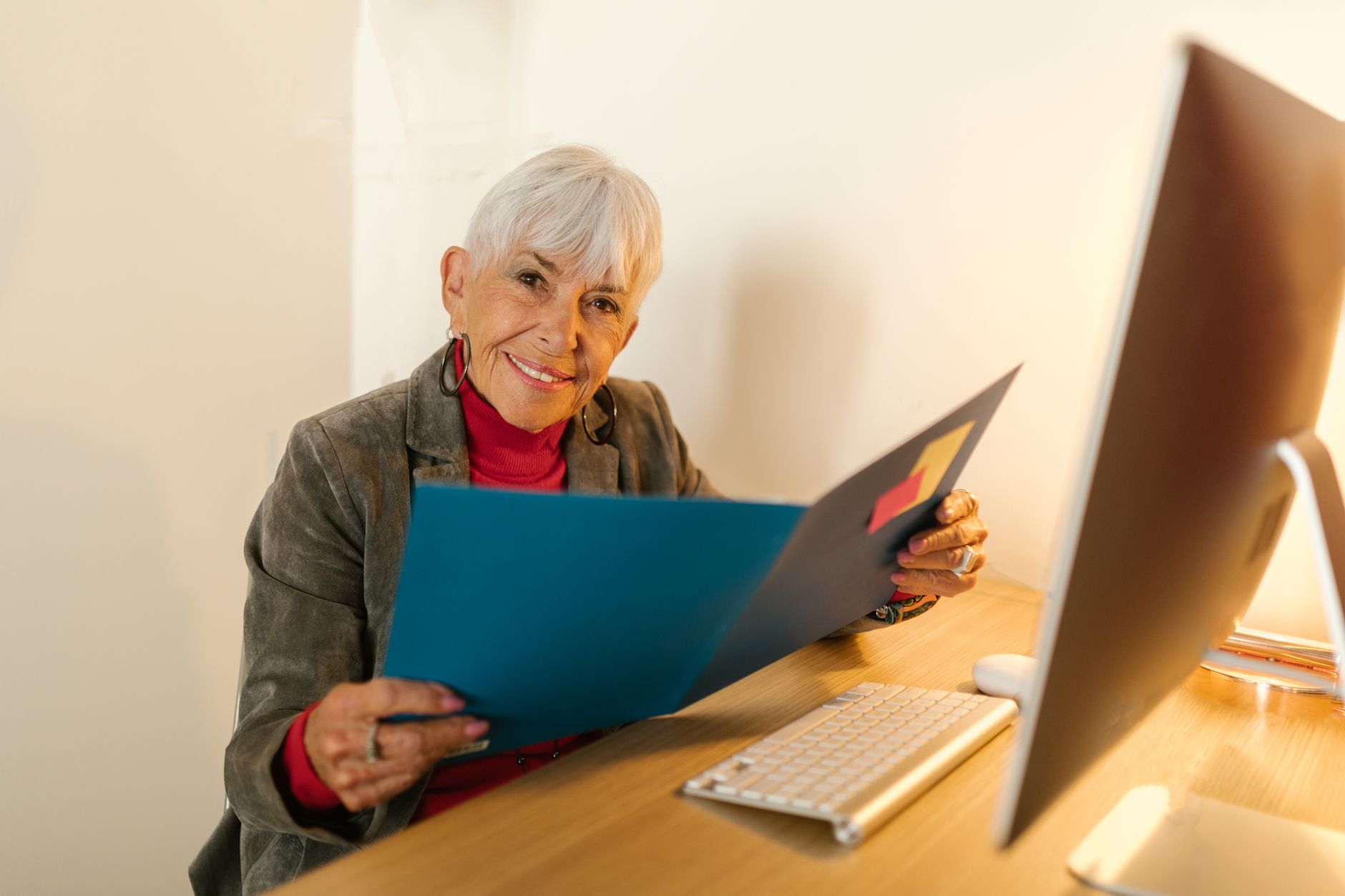 gray haired woman holding a blue folder